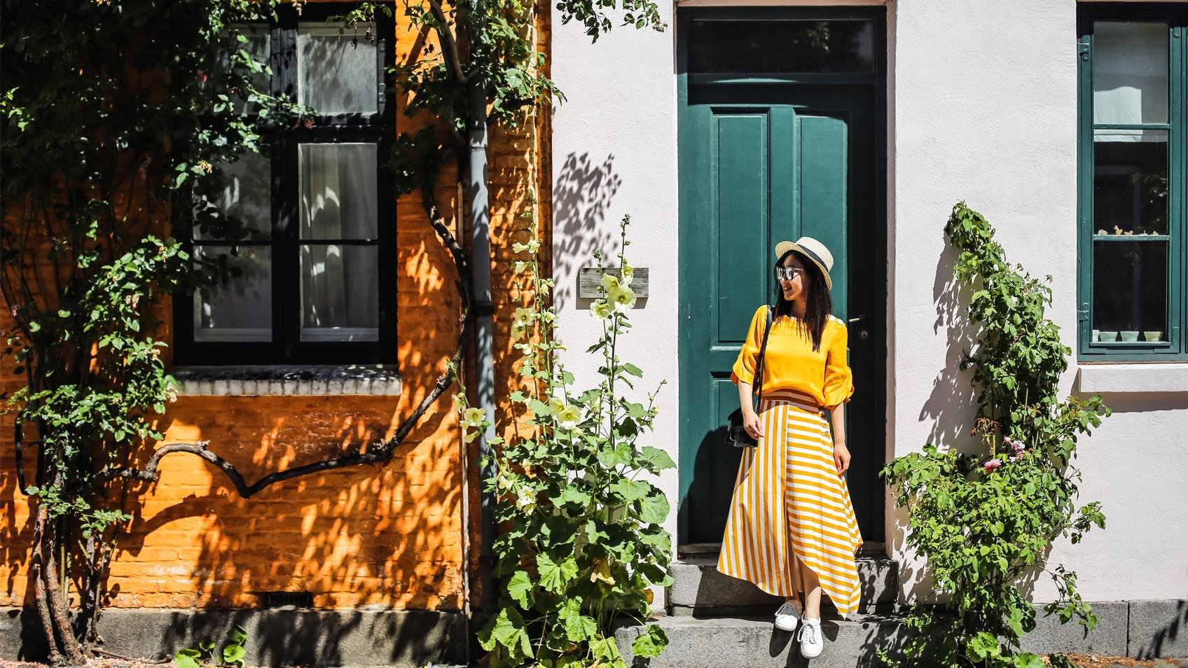 En sommerklædt kvinde står foran en hoveddør