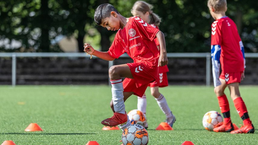 Dreng dribler med fodbold